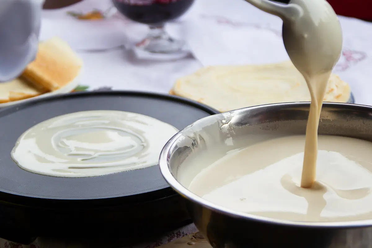 Massa de crepioca cozinhando na frigideira.