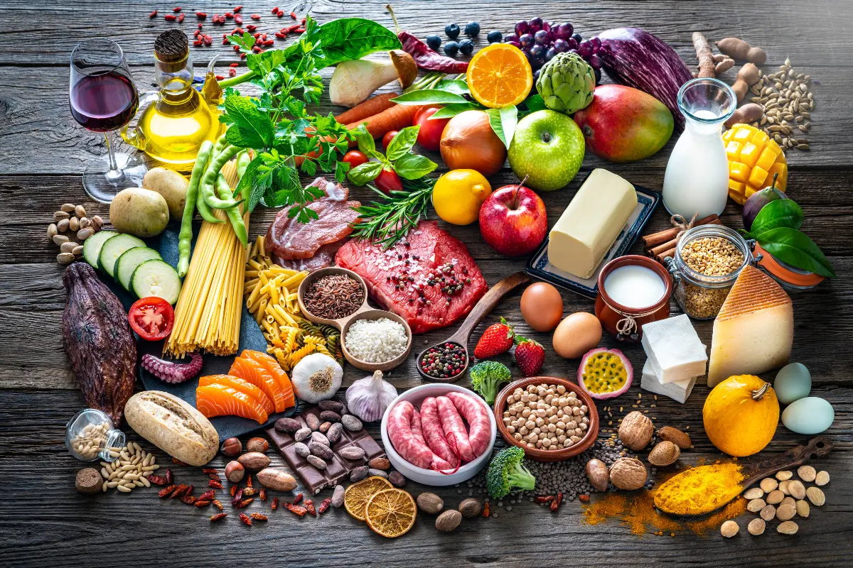 O que Comer em uma Dieta Vegana. Uma variedade de alimentos veganos, como frutas, legumes e grãos. Foto: Reprodução / Canva Pro.