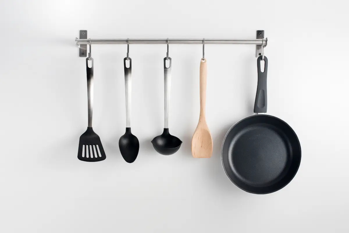 Utilize ganchos para liberar espaço e organizar os utensílios.