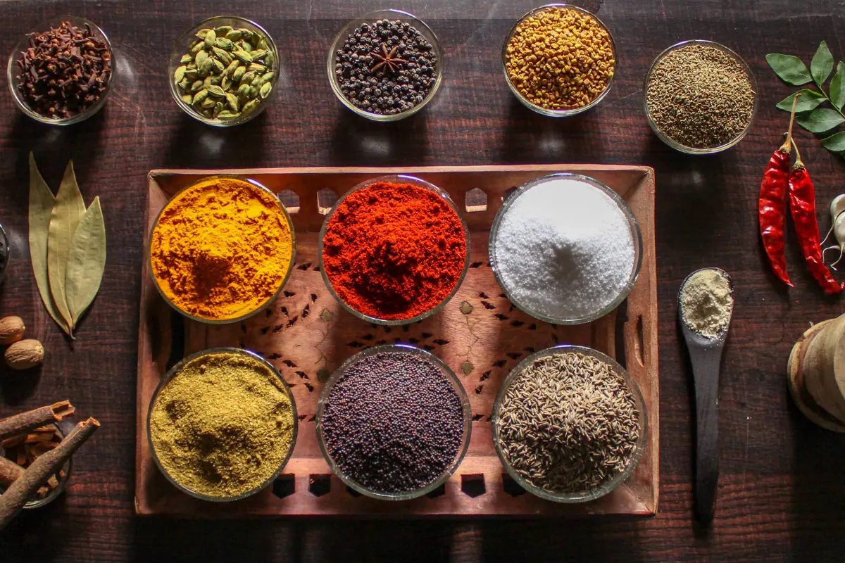 Uma seleção de temperos veganos essenciais, desde hortelã fresca até cúrcuma aromática. Foto: Reprodução / Canva Pro.