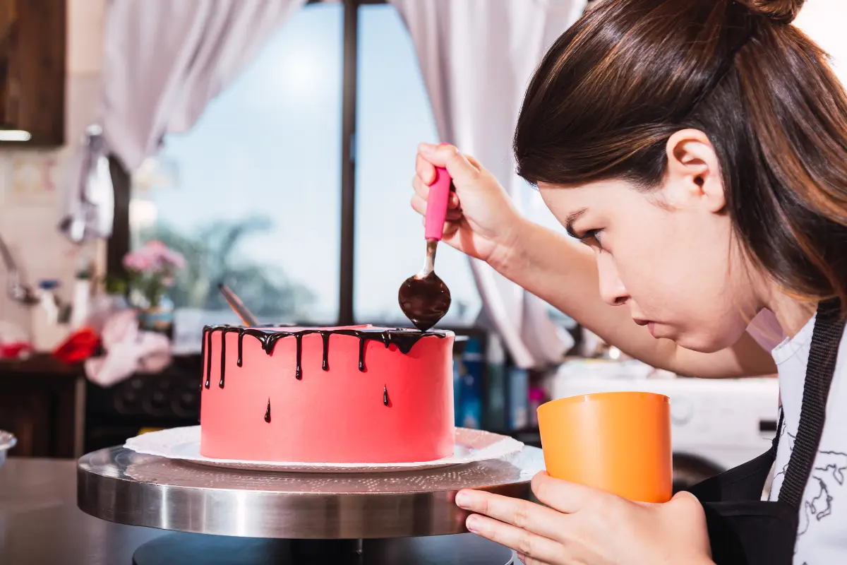 A frustração de uma confeiteira ao lidar com um bolo rachado. Foto: Reprodução / Canva Pro.