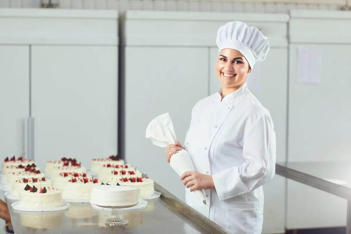 Confeiteiro garantindo um acabamento impecável ao aplicar pasta americana. Foto: Reprodução / Canva Pro.